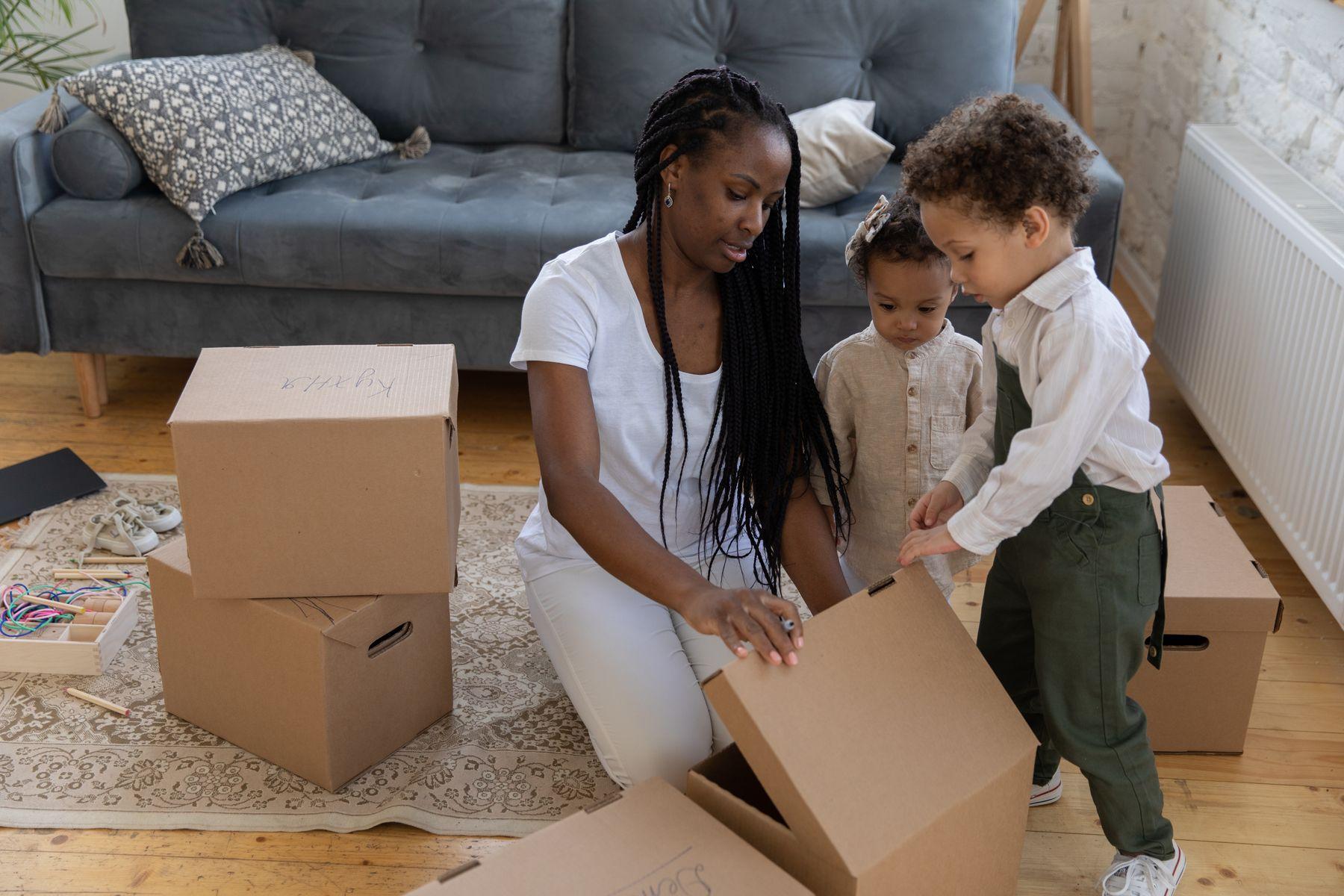 A mother and her children unpacking moving boxes in a new home